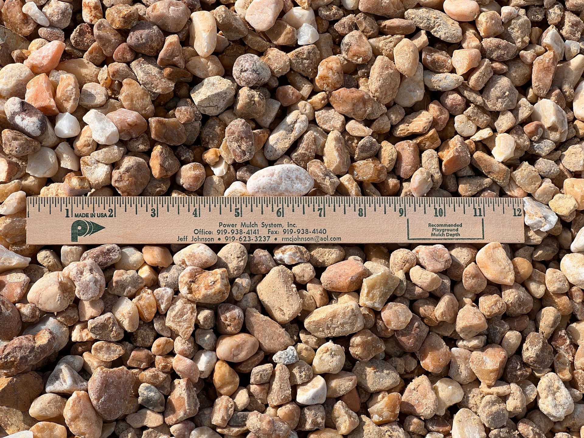 Tan and brown gravel with a ruler laid across the center.