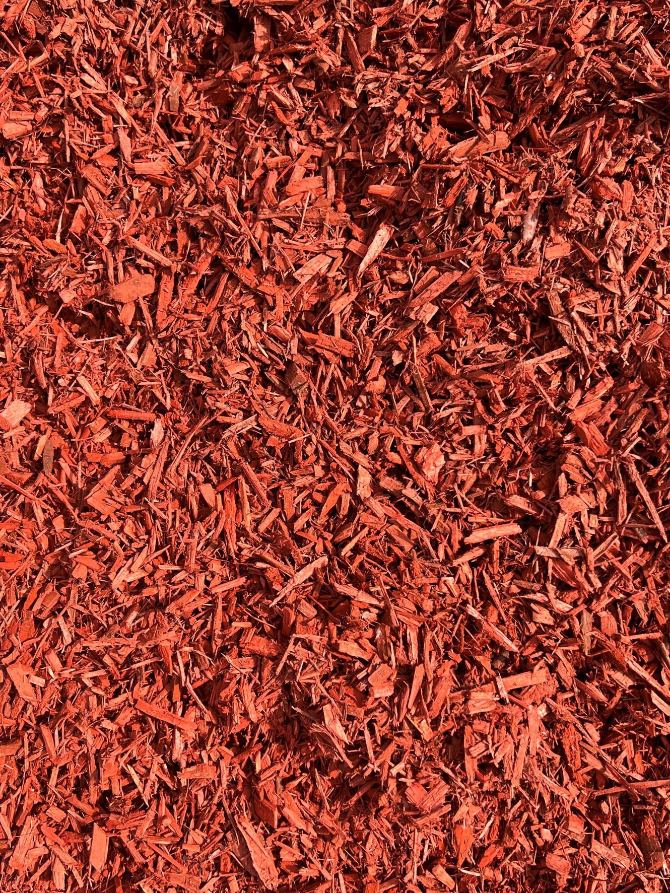 Red-colored wood chips, evenly spread, covering a surface.