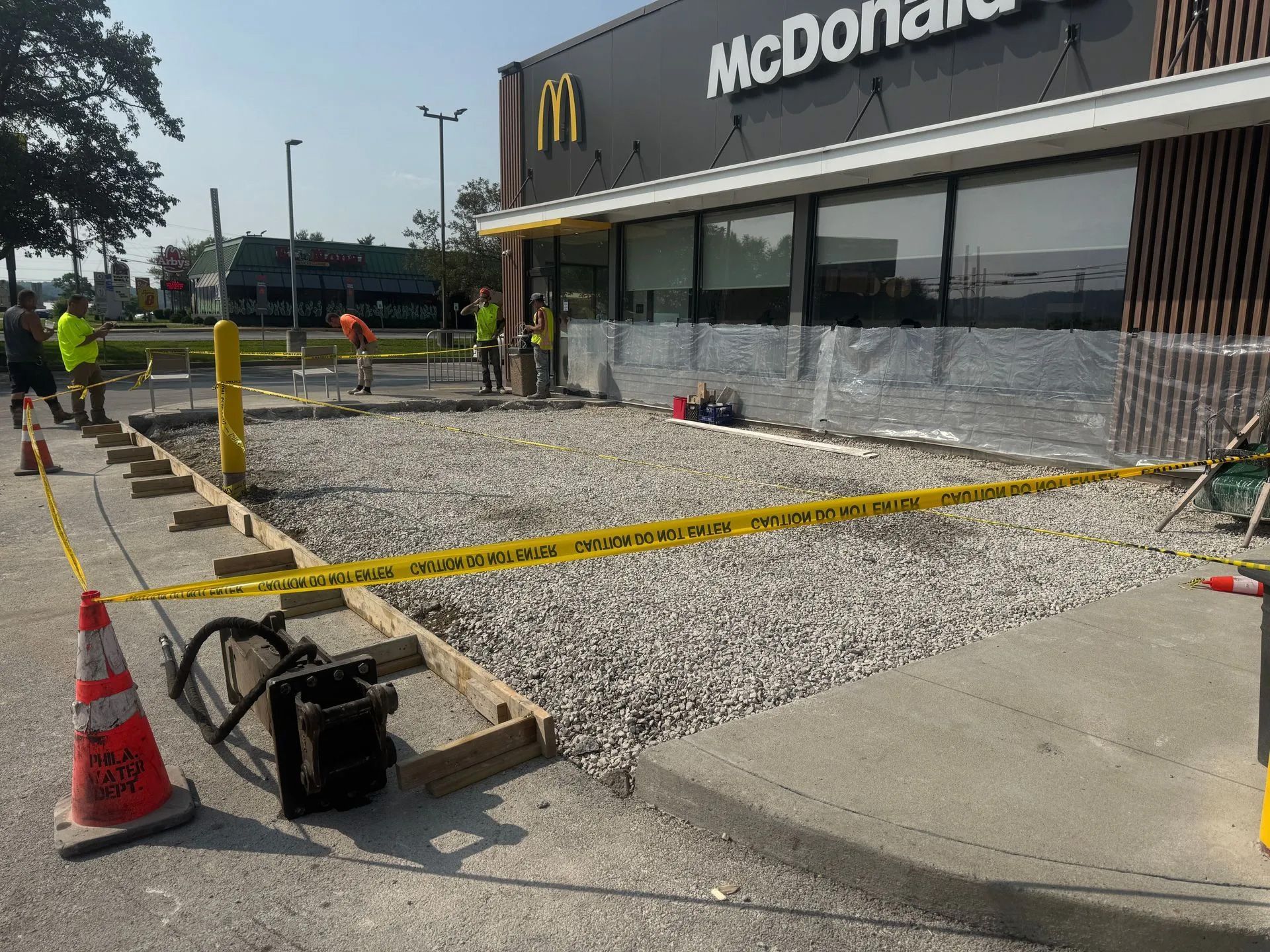 McDonald’s exterior under construction with gravel, caution tape, cones, and barricades