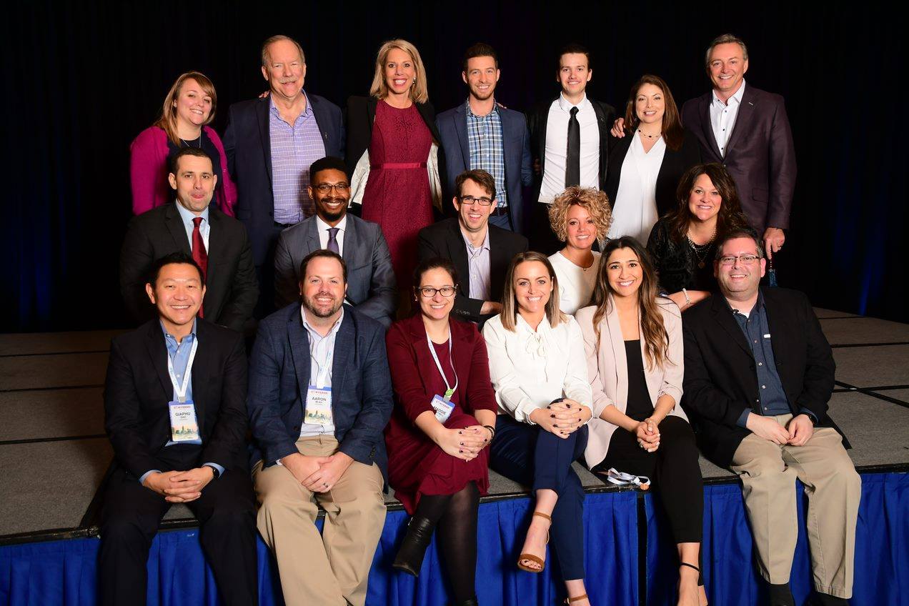 A group of people are posing for a picture on a stage.