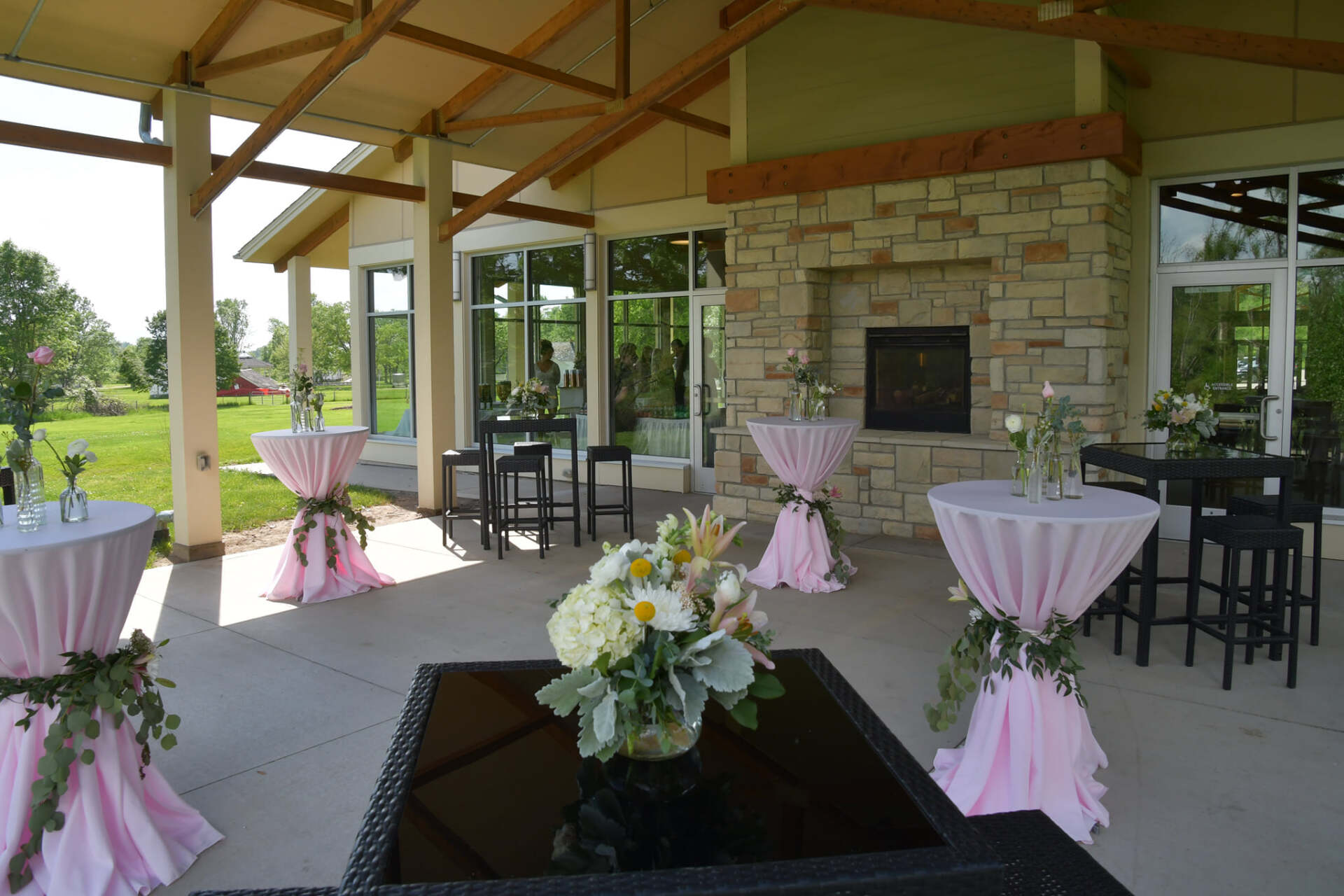 A room with tables and chairs and a vase of flowers on a table.