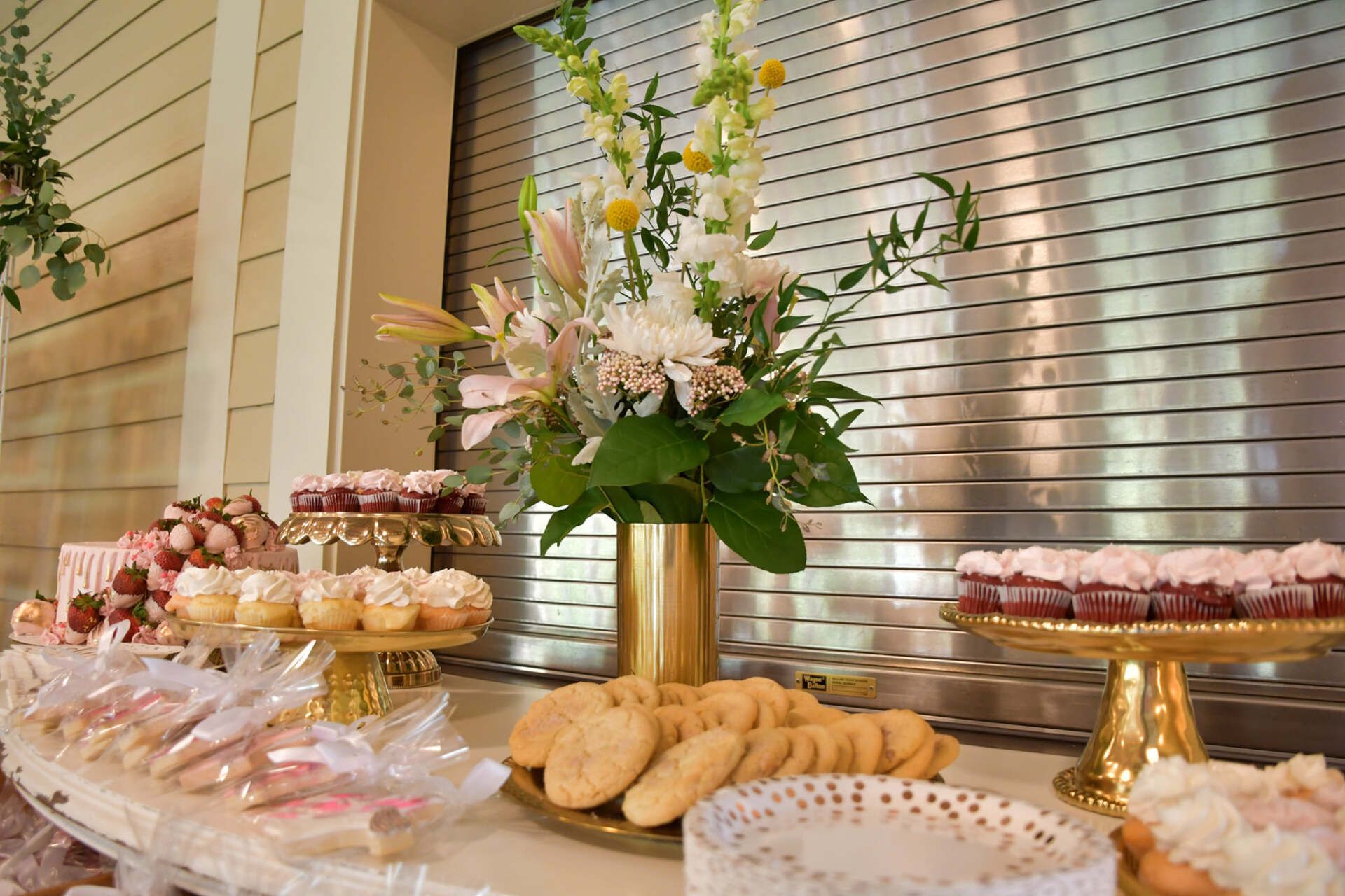 A table topped with a variety of desserts and flowers.