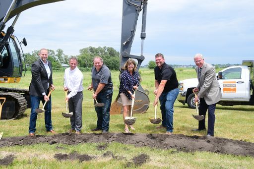 A group of people are shoveling dirt in a field.