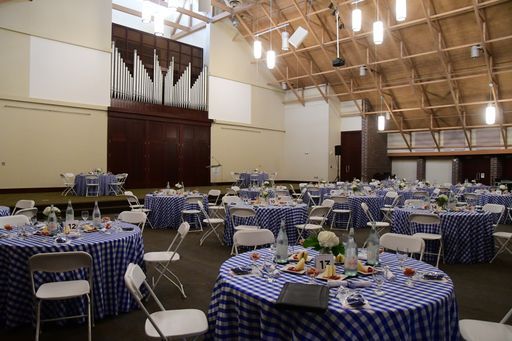 A large room with tables and chairs set up for a party