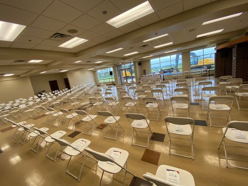 Rows of folding chairs are lined up in a large room.