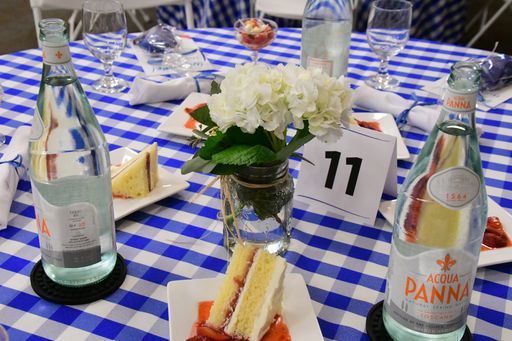 A table with a checkered tablecloth and a bottle of panna water