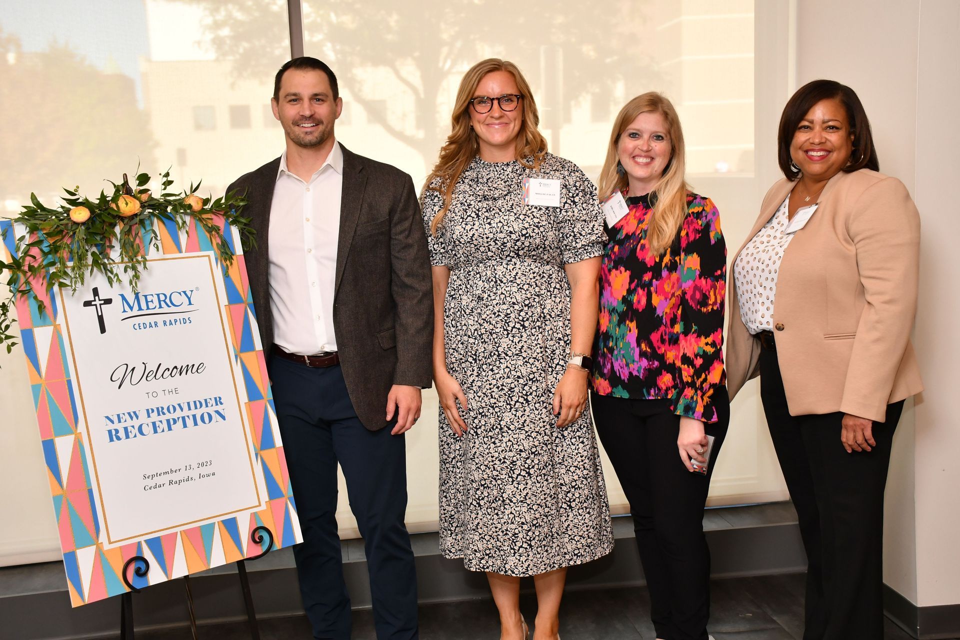 four people standing with the event board