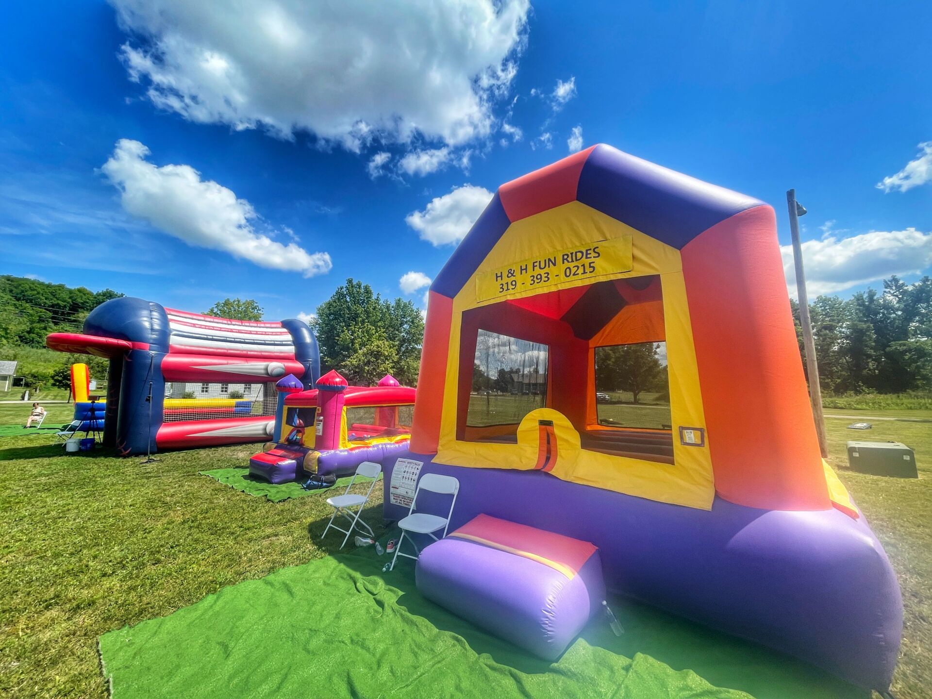 A bunch of bouncy houses are sitting on top of a lush green field.