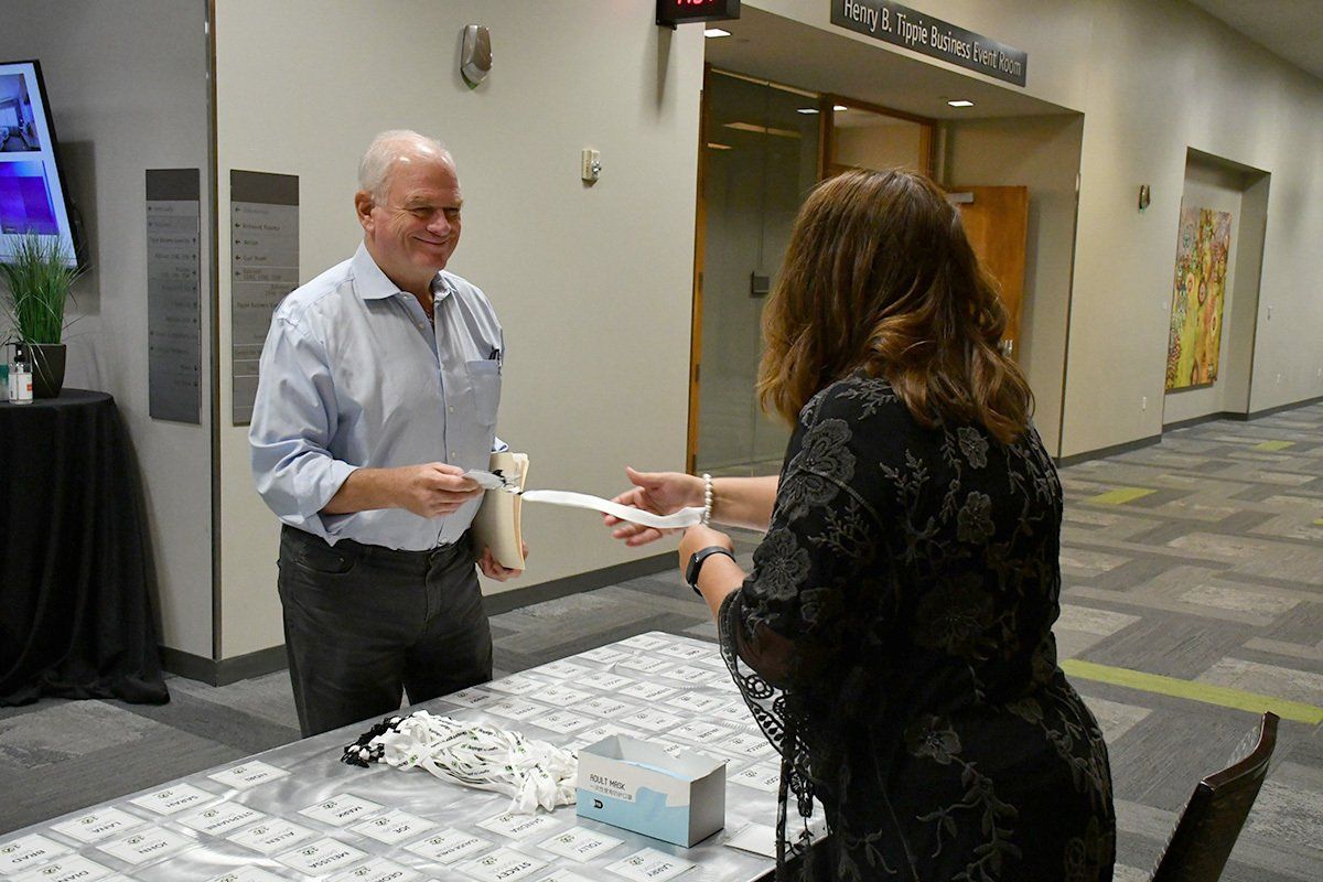A woman assisting a man at a corporate event