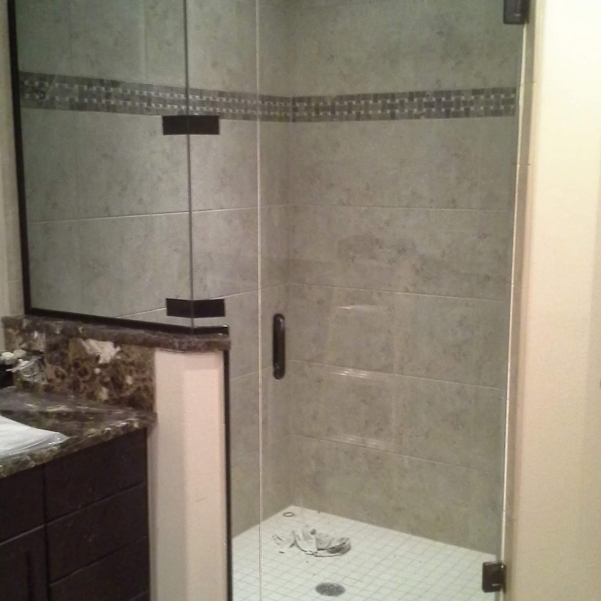 A bathroom with a walk in shower and a sink