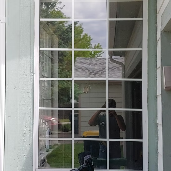 A man is taking a picture of himself in a window.