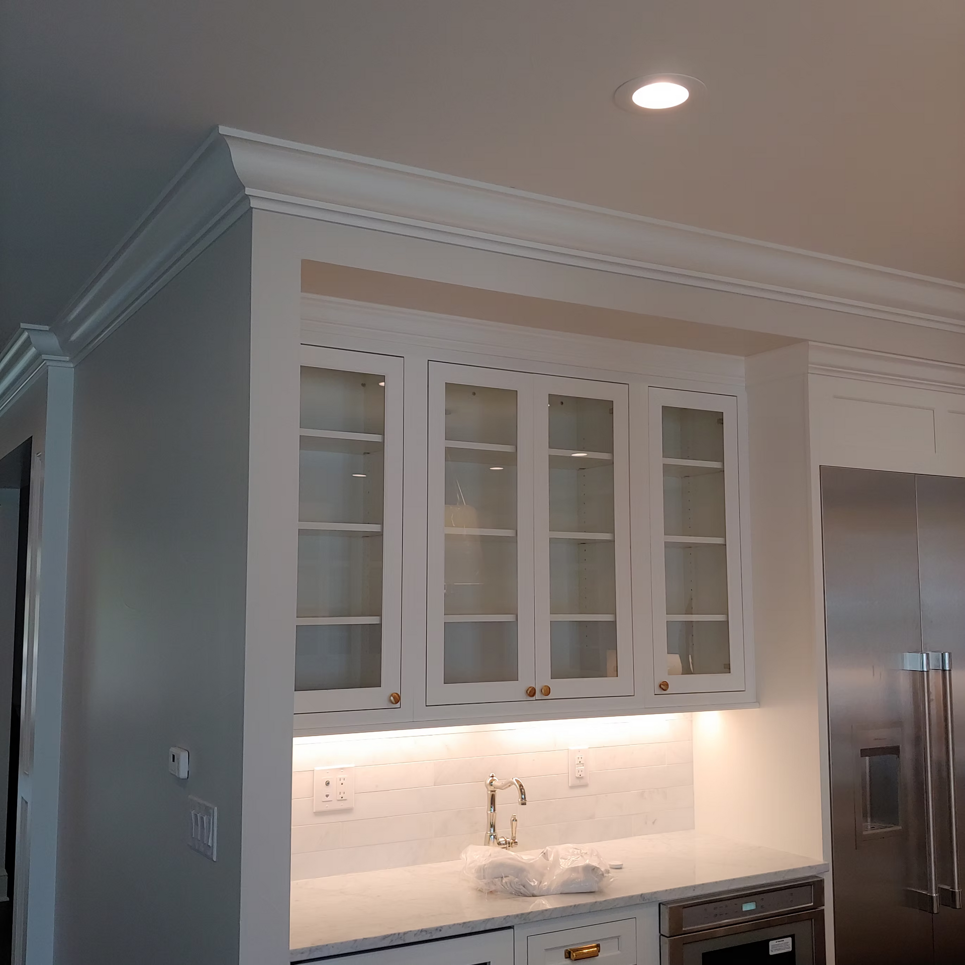 A kitchen with white cabinets and stainless steel appliances