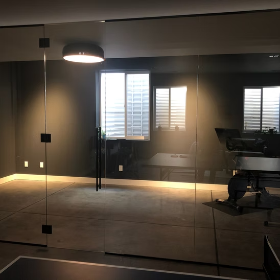 A room with a table and chairs behind a glass wall