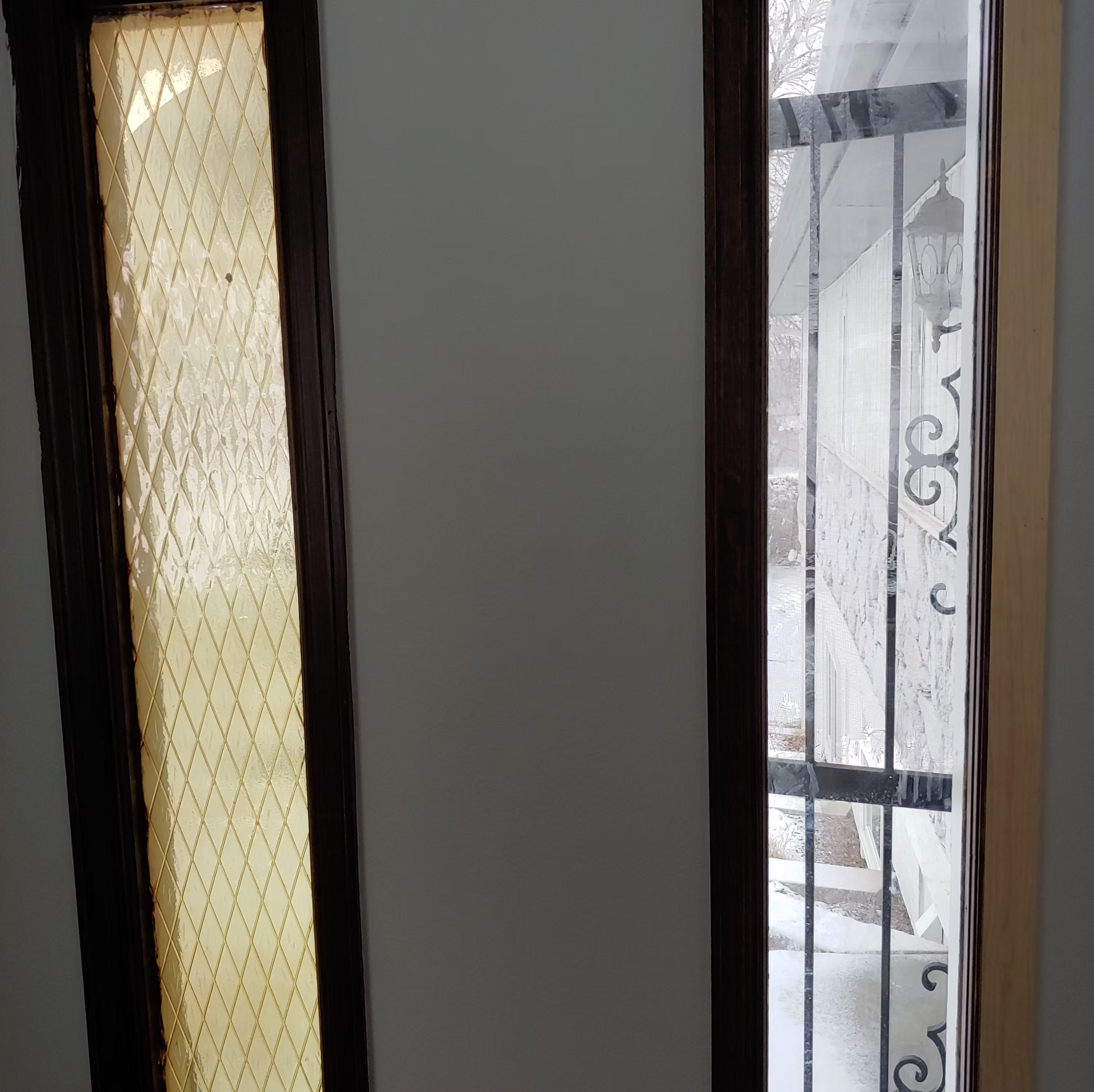 A door with a stained glass window and a wrought iron railing