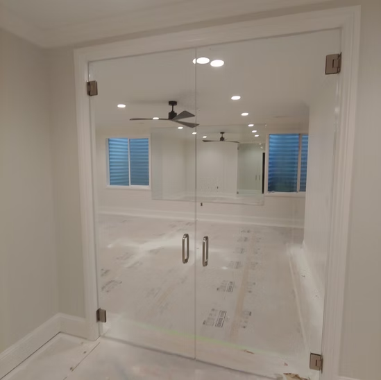 A room with a glass door and a ceiling fan