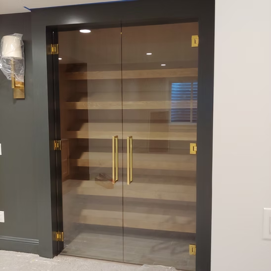 A glass door with gold handles in a room