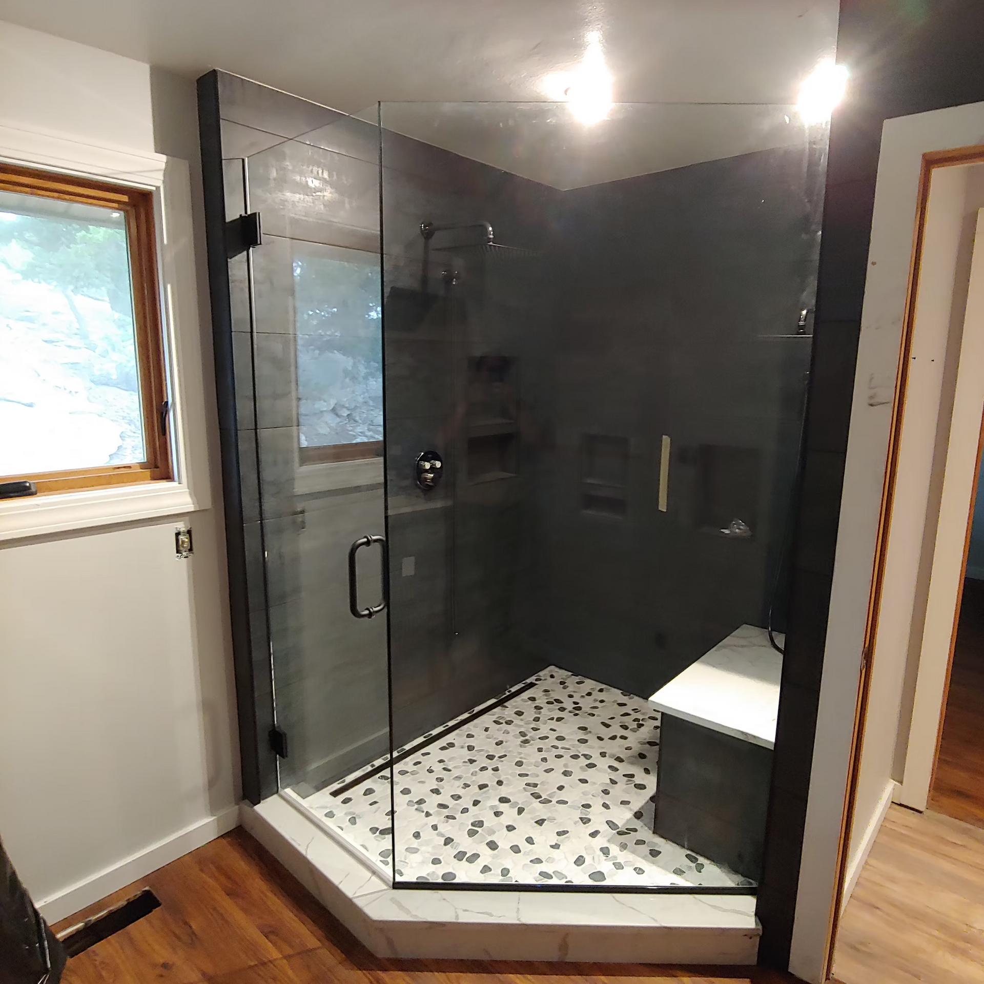 A bathroom with a walk in shower and a window
