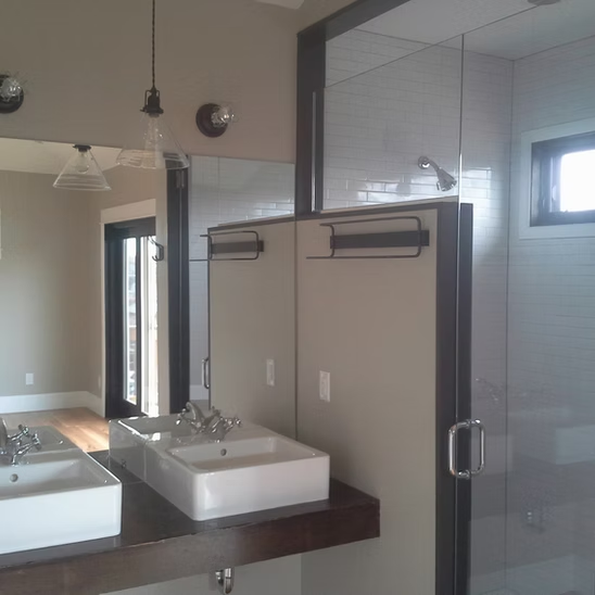 A bathroom with two sinks and a large mirror