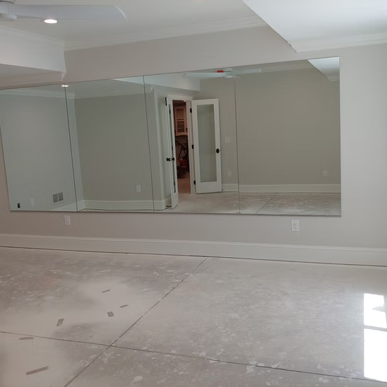 An empty room with a large mirror on the wall