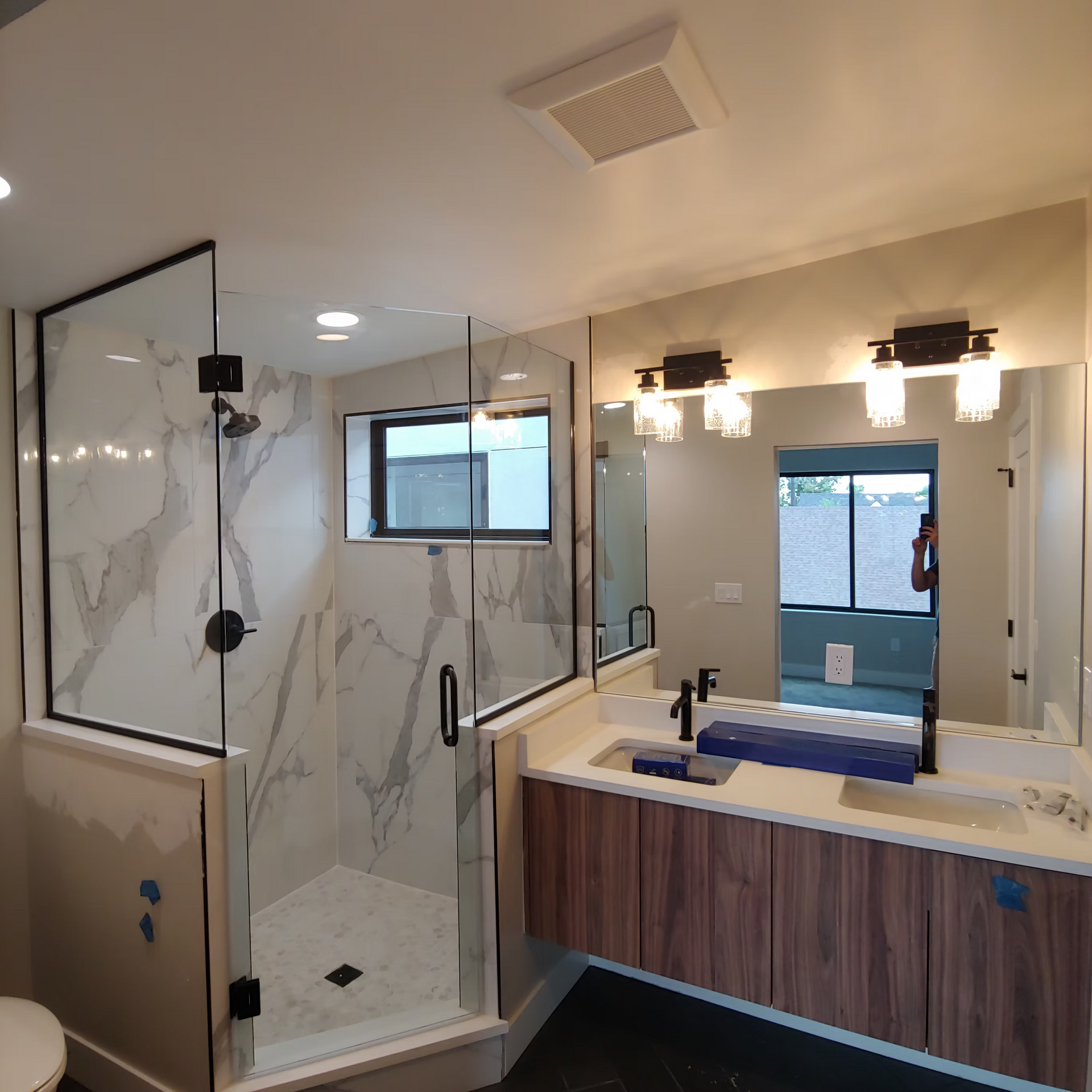 A bathroom with a walk in shower , sink and mirror