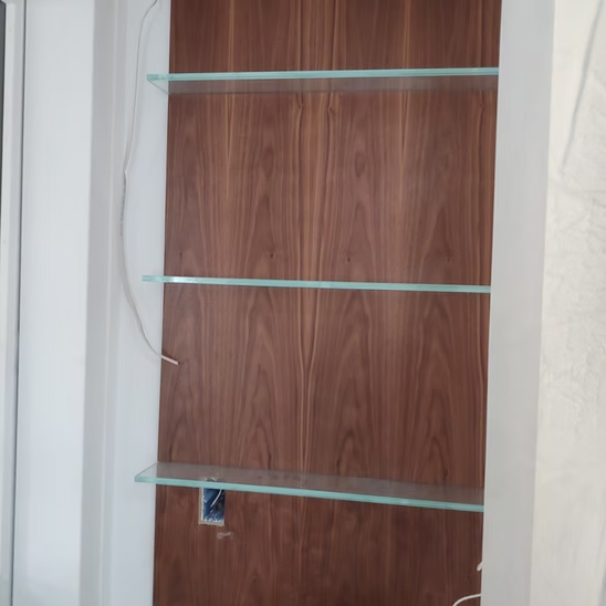 A wooden wall with glass shelves on it