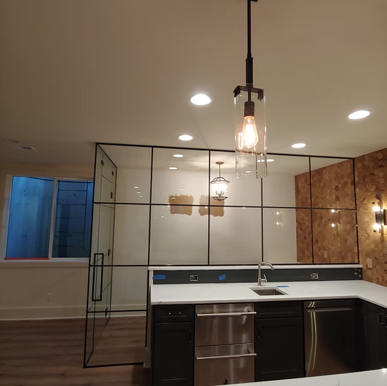 A kitchen with stainless steel appliances and a glass wall