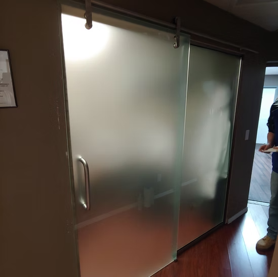 A man standing in a hallway next to a sliding glass door