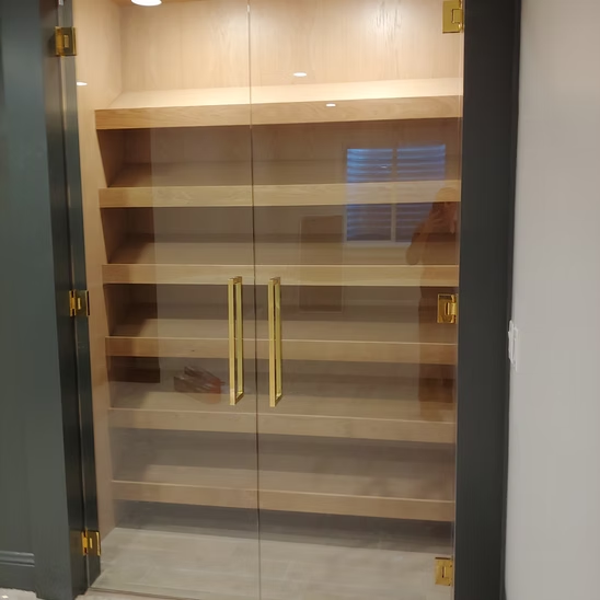 A glass door with wooden shelves inside of it