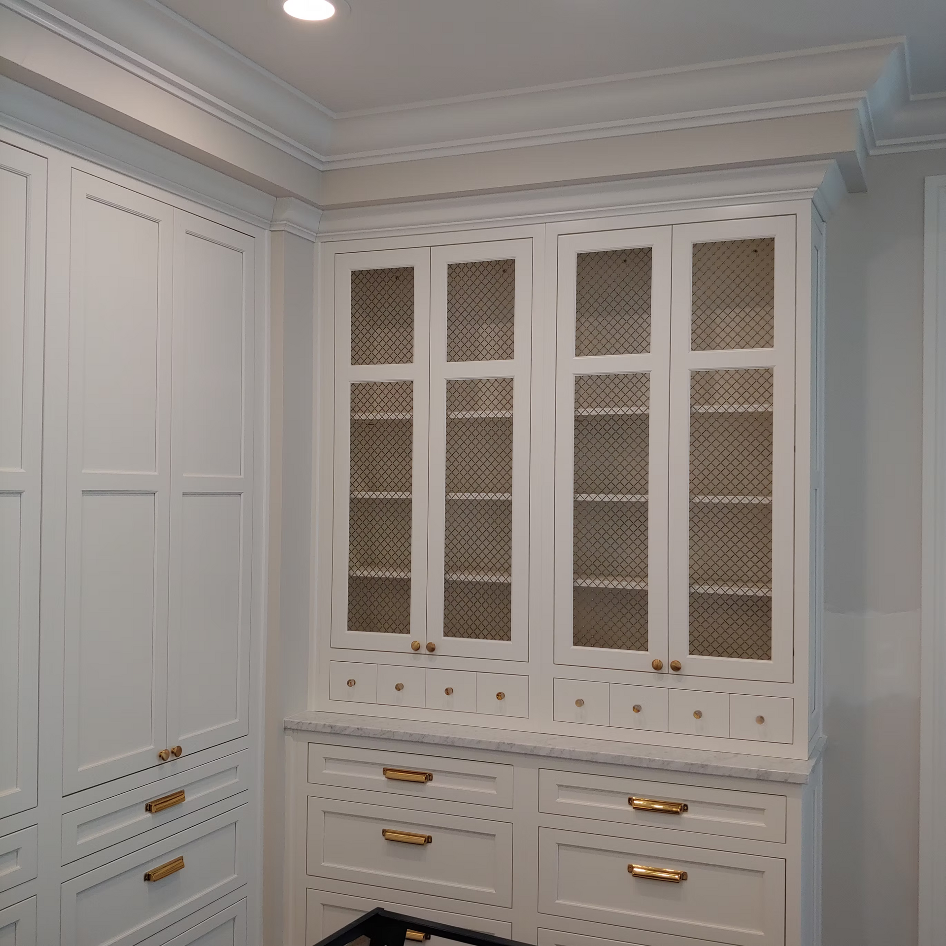 A room with lots of white cabinets and drawers