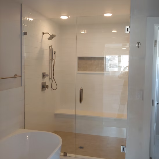A bathroom with a bathtub and a shower with a glass door.