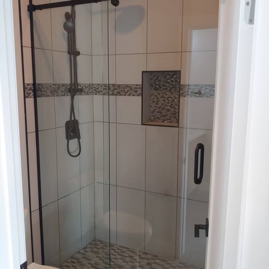A bathroom with a sliding glass shower door