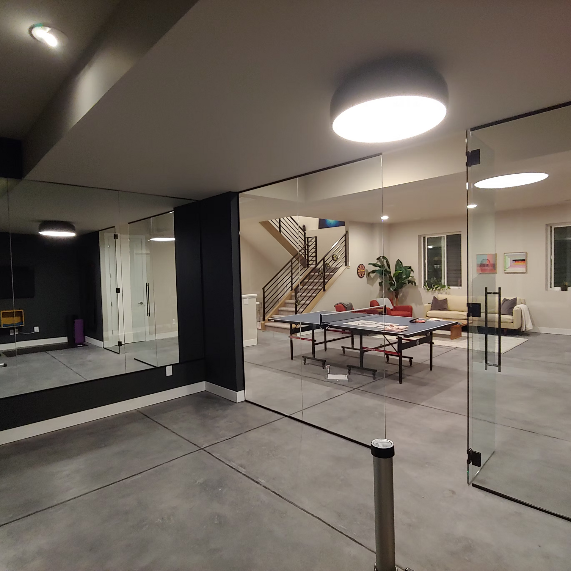 A room with a ping pong table and a mirror