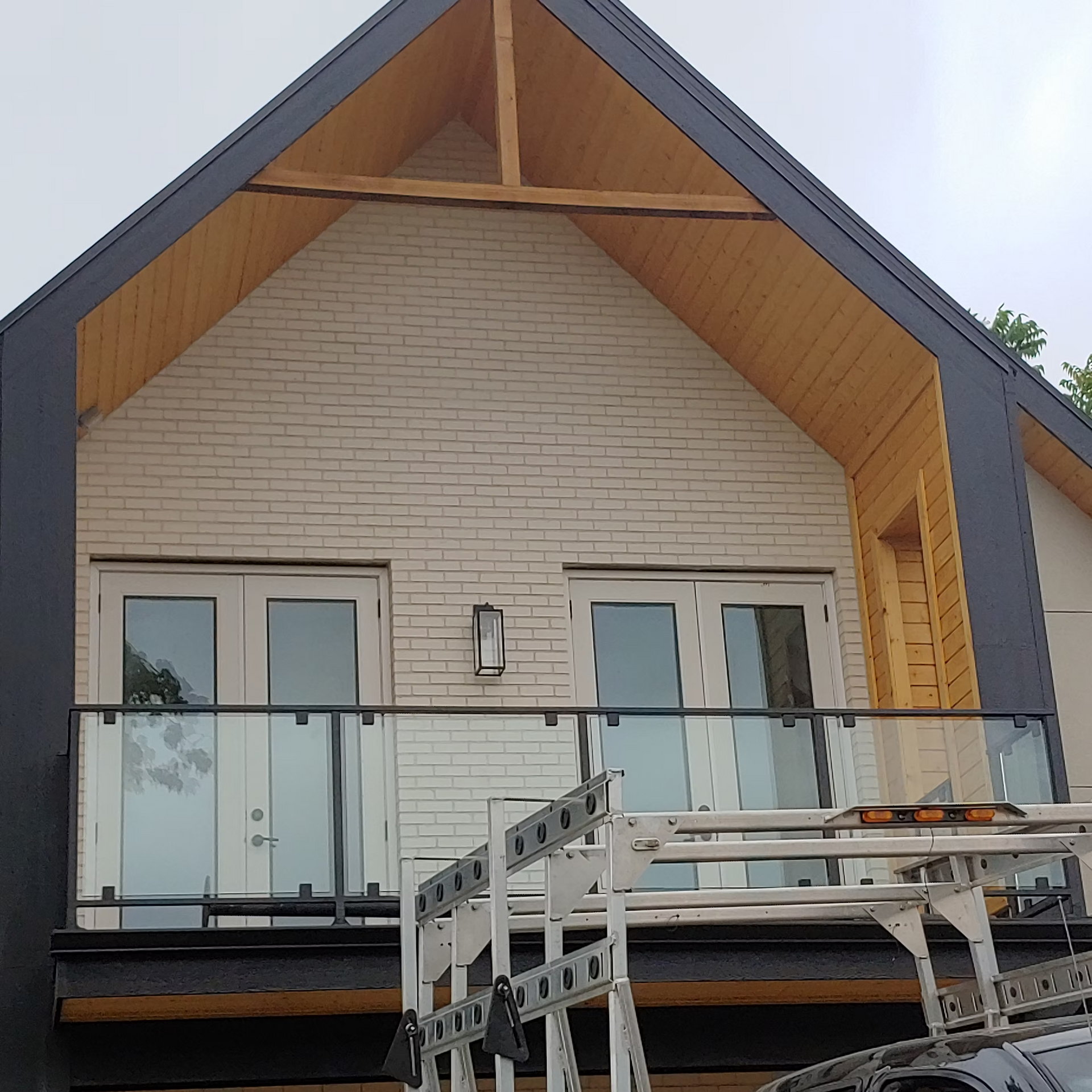 A house with a balcony and a car parked in front of it