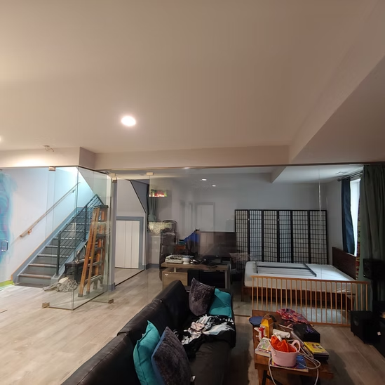 A living room with a couch and stairs in the background