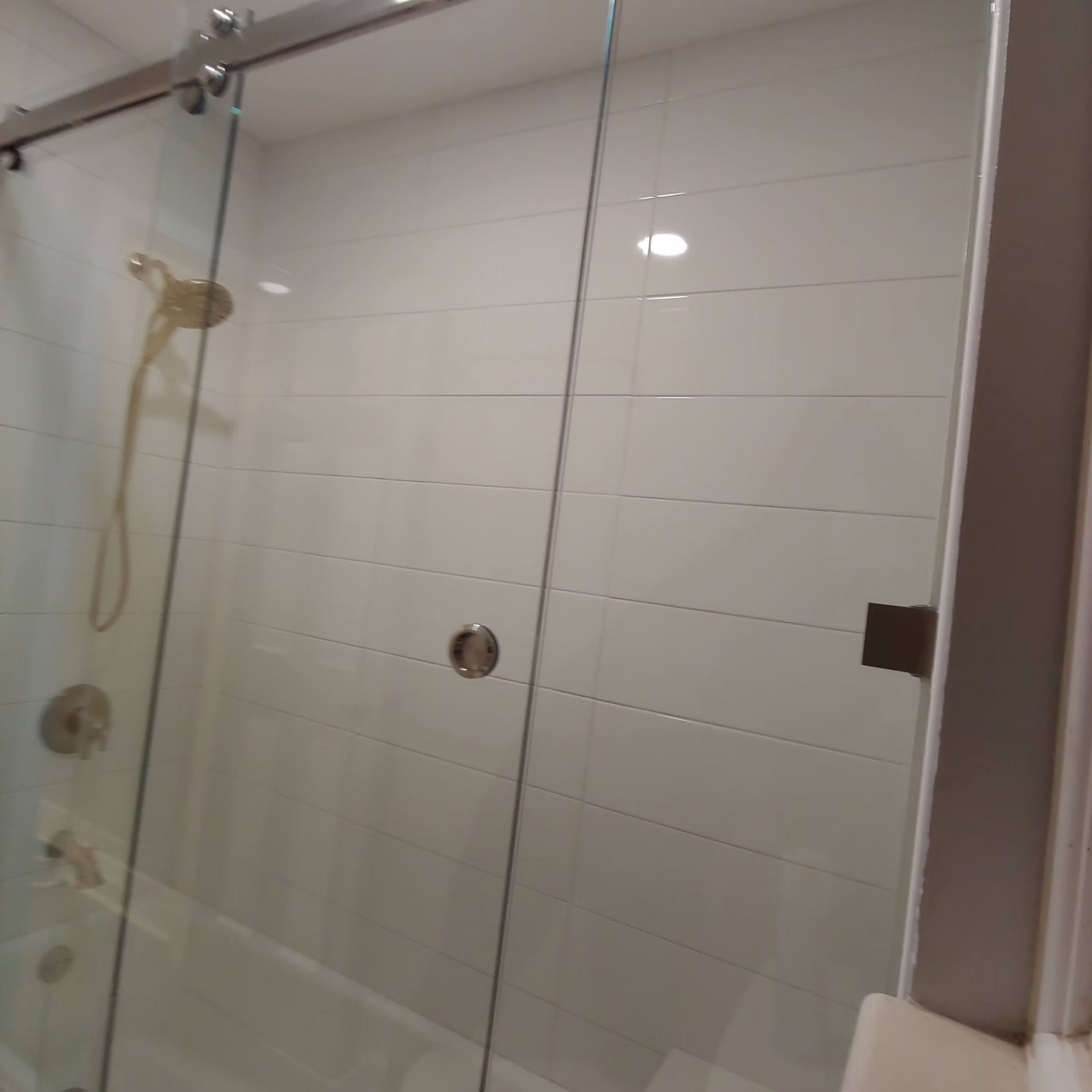 A bathroom with a sliding glass shower door and a bathtub.