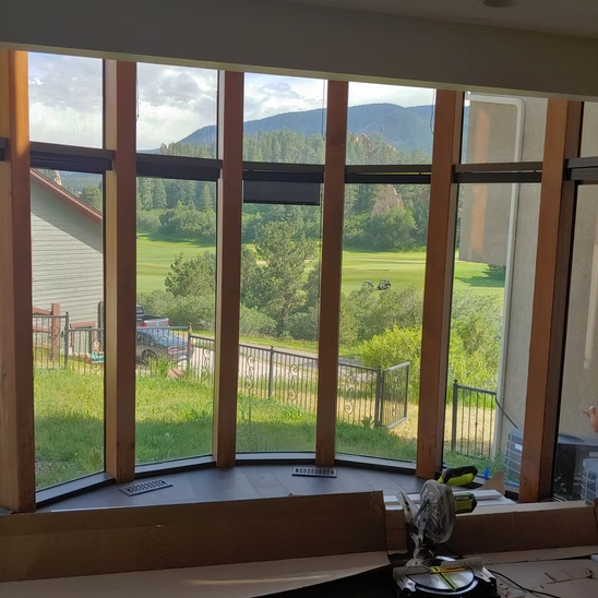 A large window with a view of a field and mountains