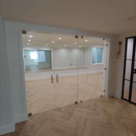 A room with a sliding glass door and a wooden floor.