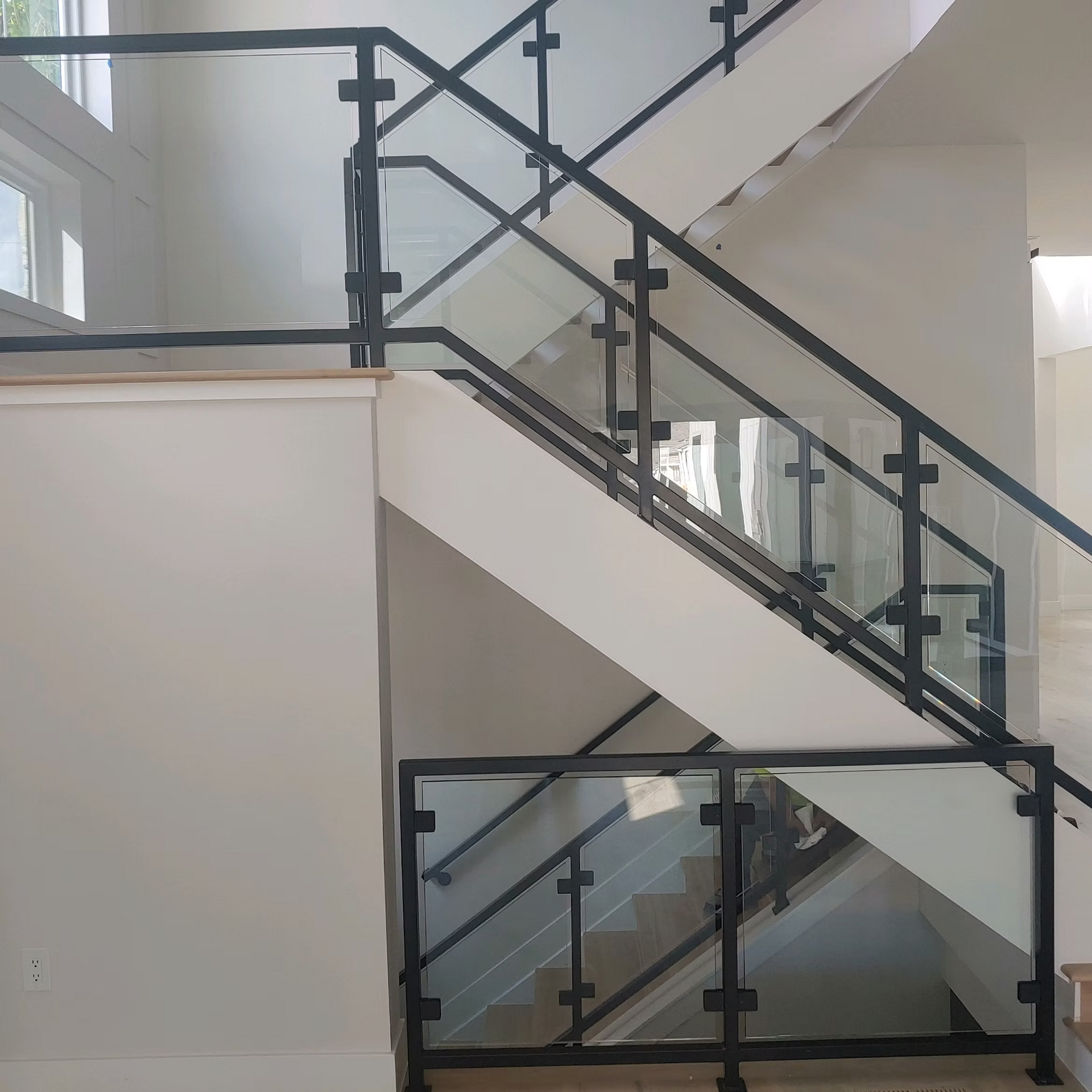 A staircase with a black railing and a glass railing