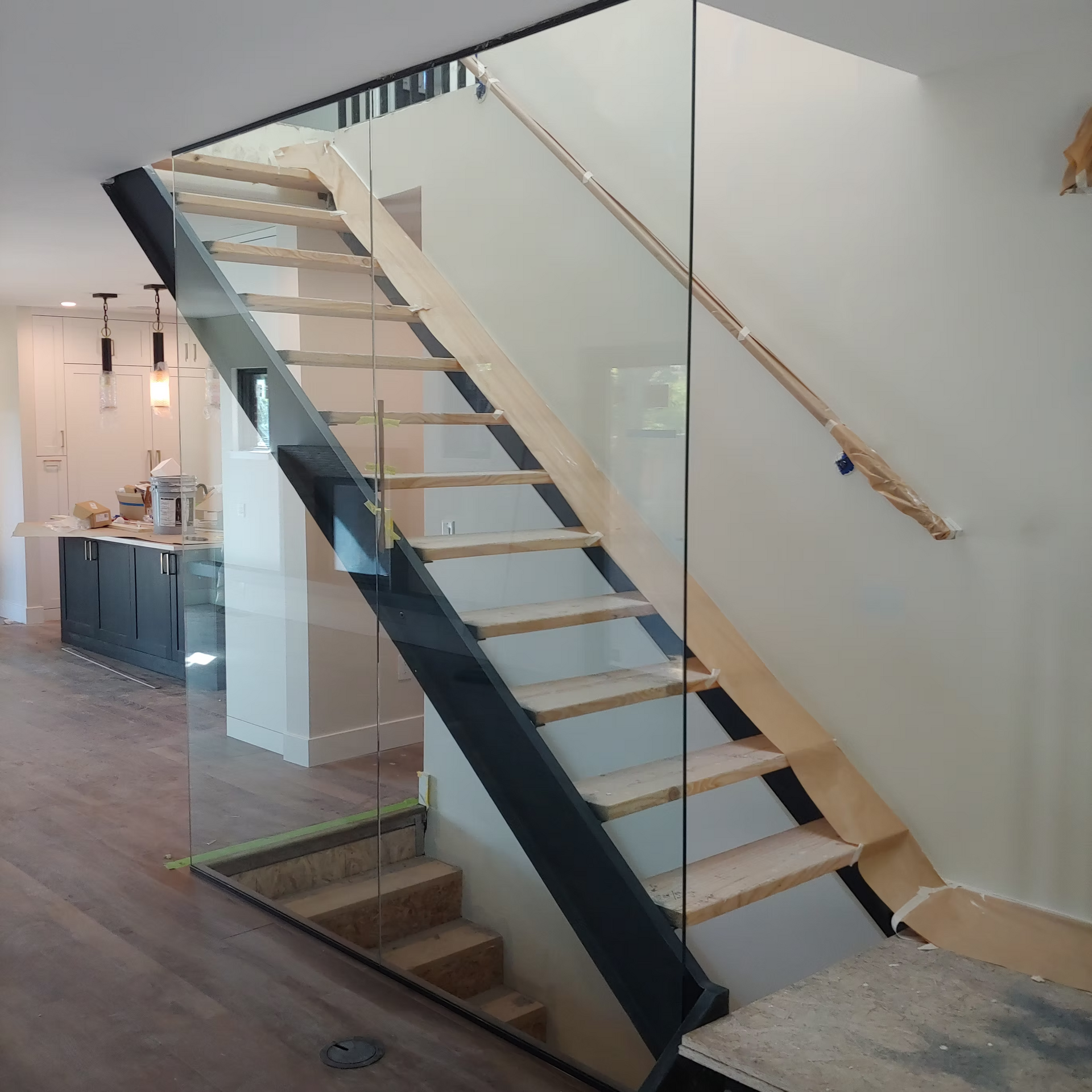 A wooden staircase with a glass railing in a house