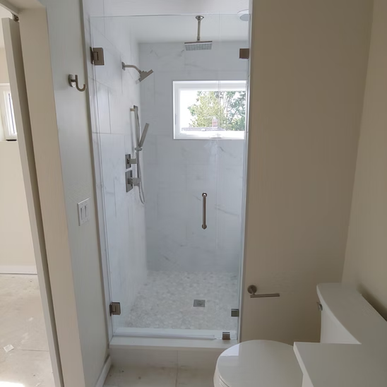 A bathroom with a toilet and a shower with a glass door