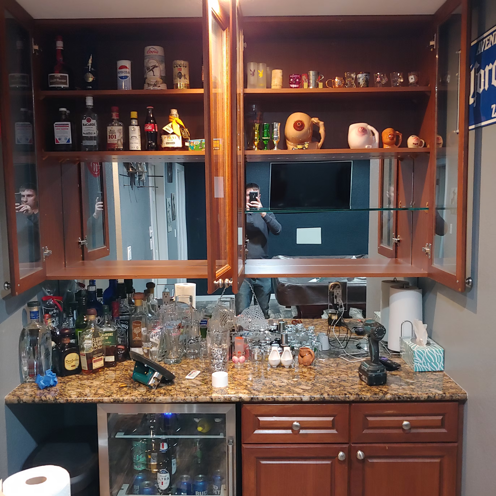 A kitchen with a lot of bottles on the shelves