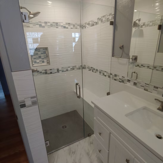 A bathroom with a sink and a walk in shower