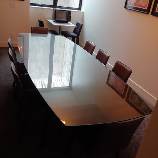 A conference room with a glass table and chairs