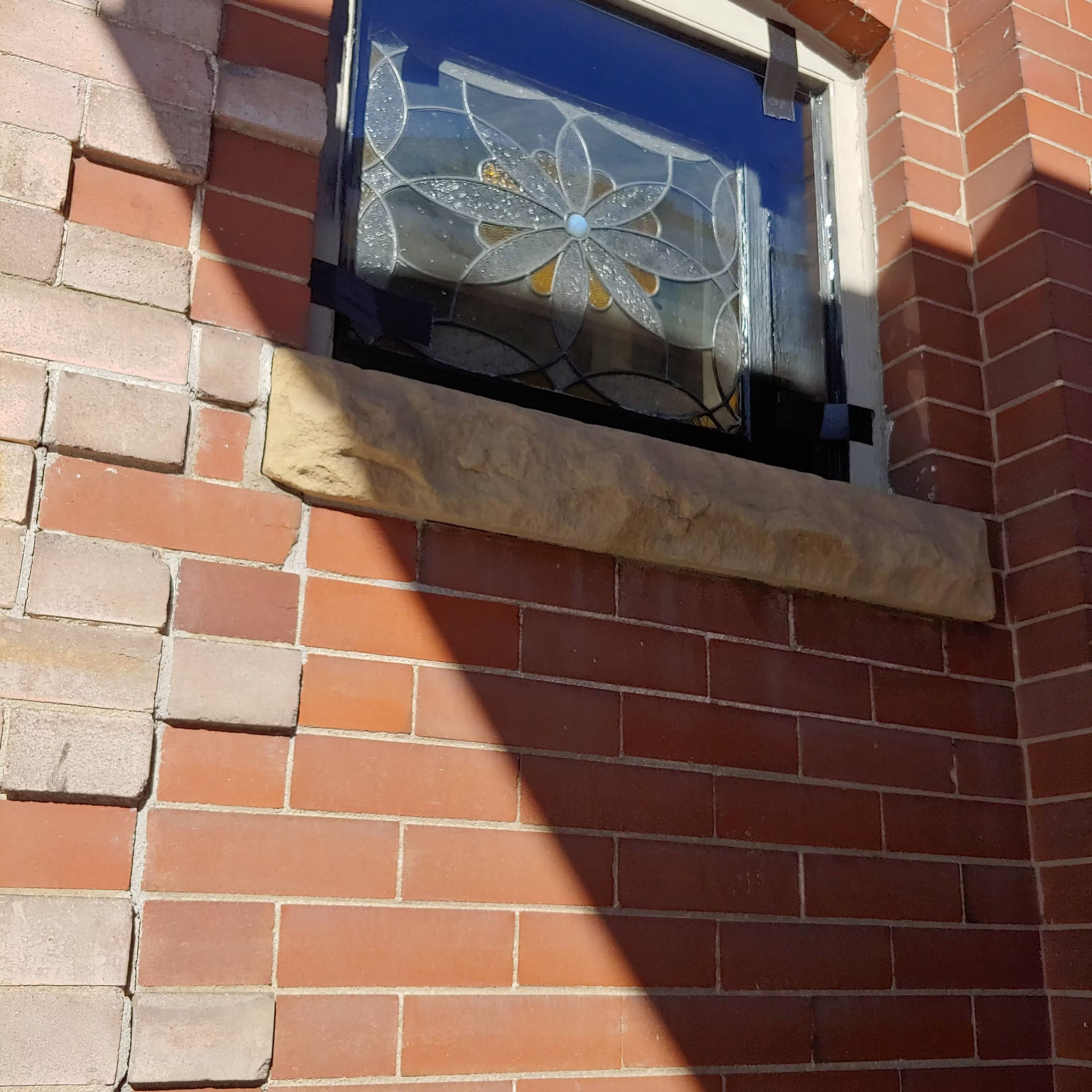 A brick wall with a stained glass window on it