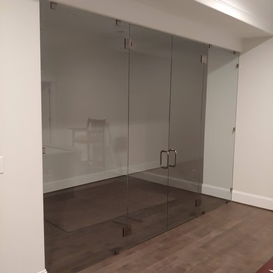 A room with a lot of glass doors and a wooden floor.