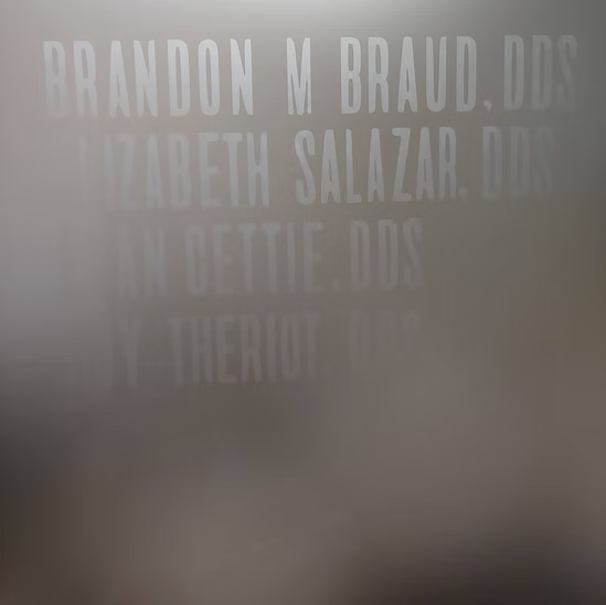 A blurred image of a sign that says brandon m braud dds