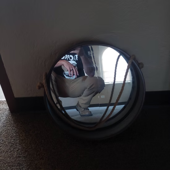 A man taking a picture of himself in a mirror with a shirt that says tcw on it