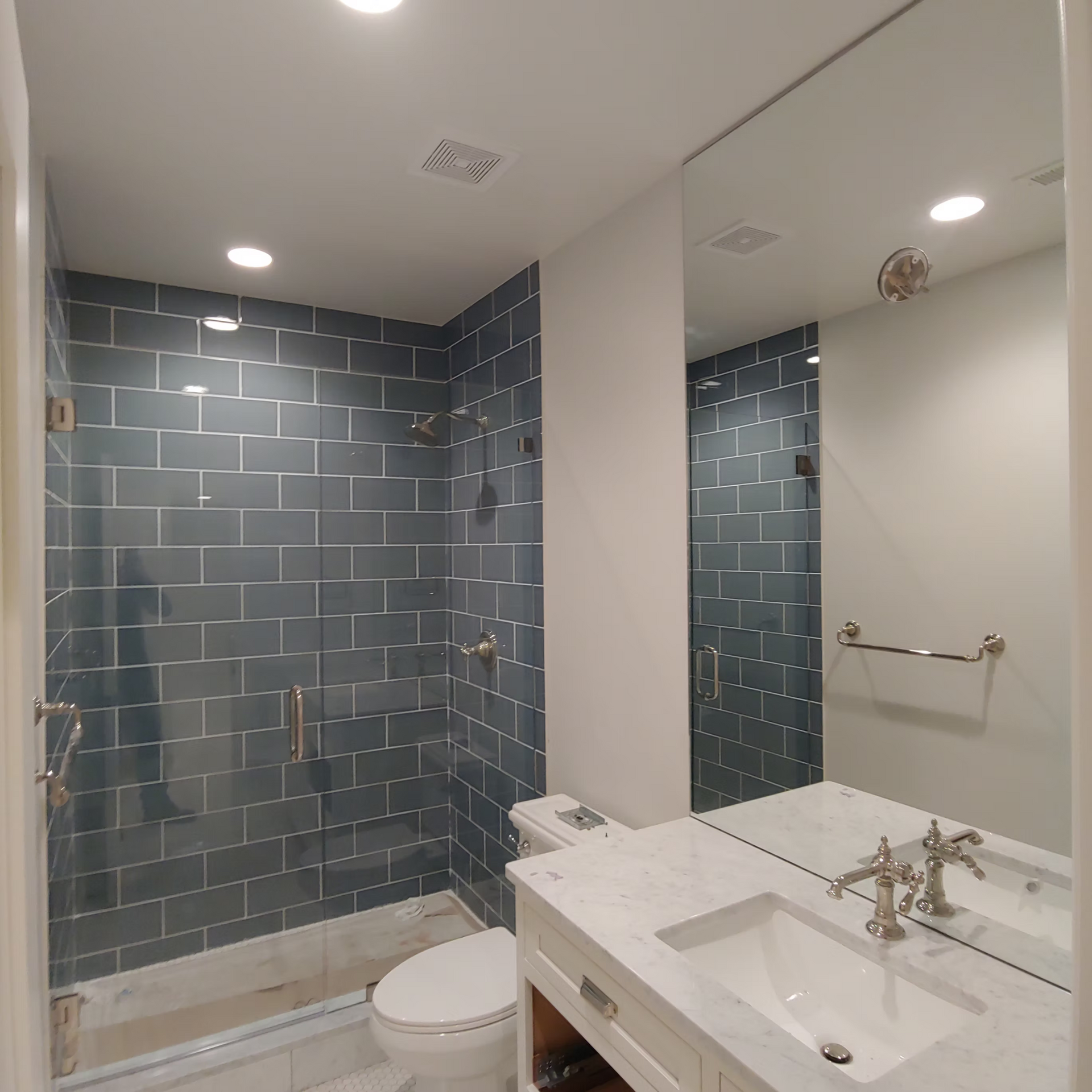 A bathroom with a toilet a sink and a mirror