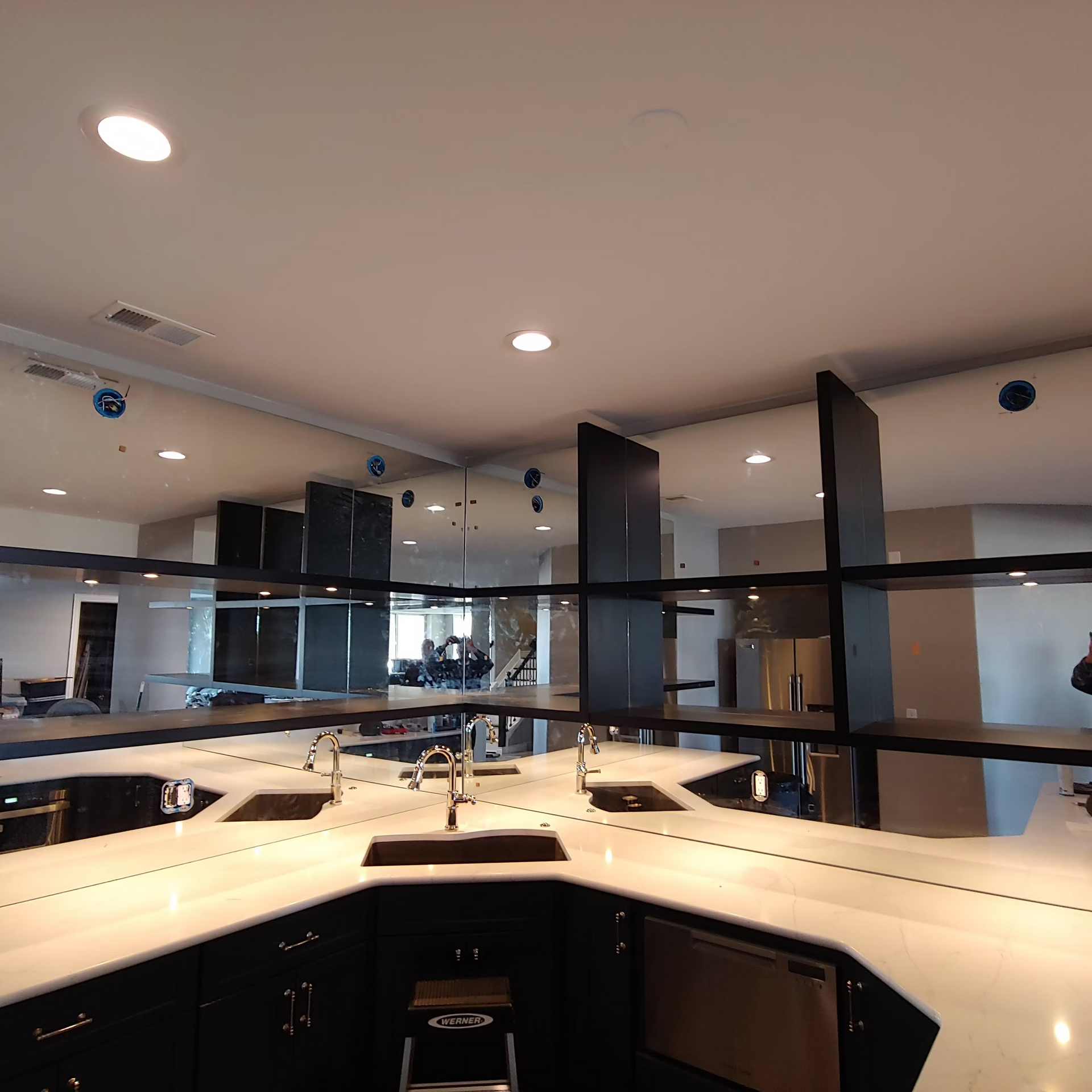 A kitchen with a lot of mirrors and shelves