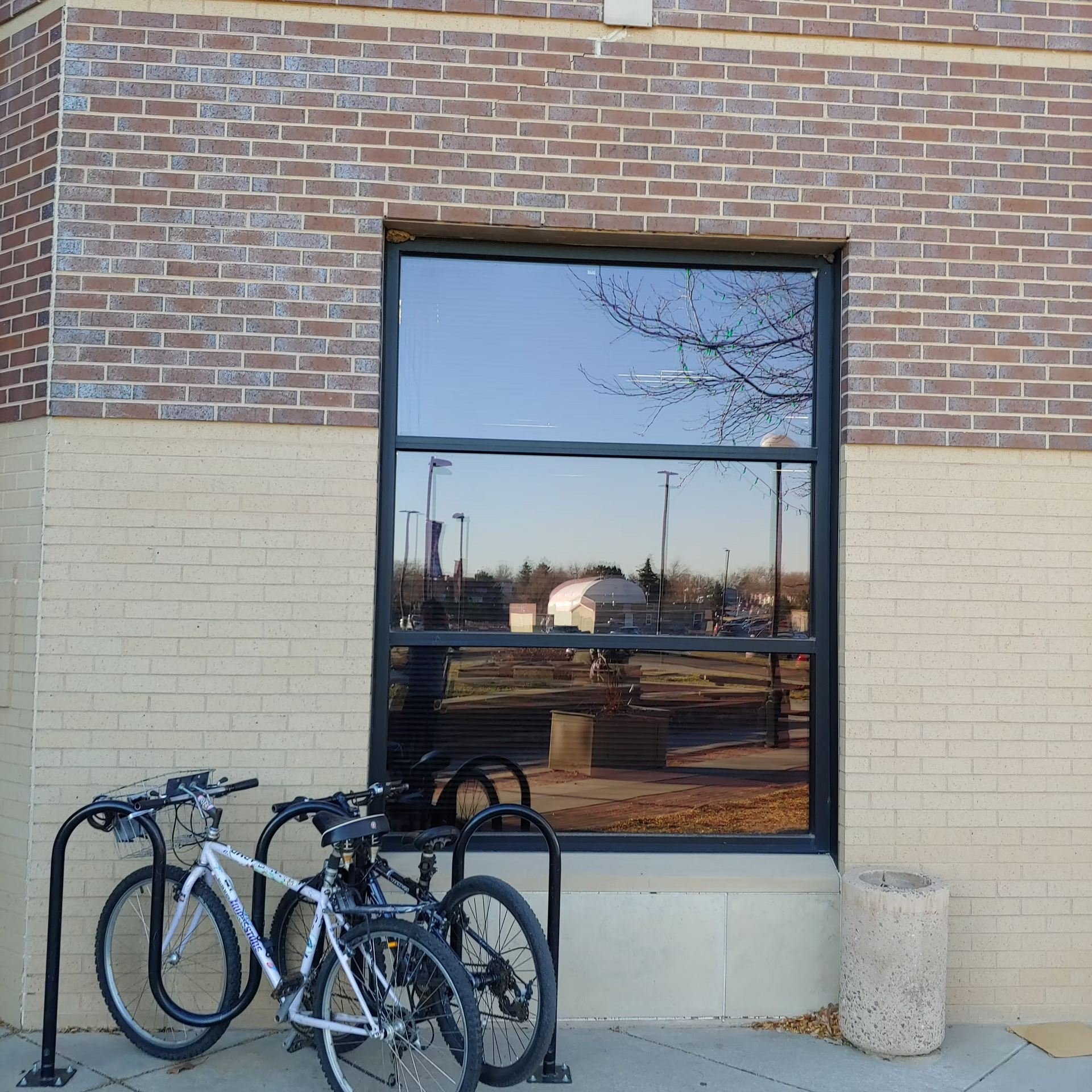 Two bicycles are parked in front of a brick building